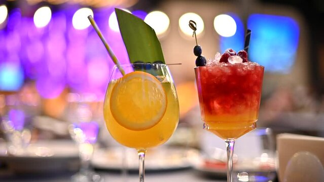 Orange and red cocktails, lemonade and vodca, mango juice, blueberries and ice