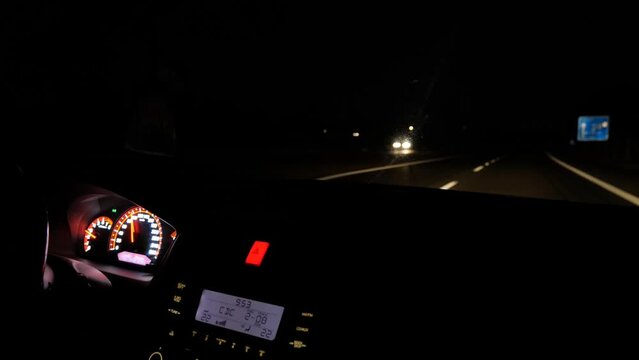 Dashboard of modern car driving at night on double land highway