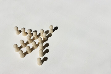 Wooden figures on a white background, which form the shape of an airplane. Concept of teamwork,...