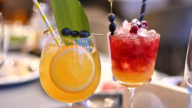 Orange and red cocktails, lemonade and vodca, mango juice, blueberries and ice