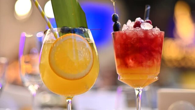 Orange and red cocktails, lemonade and vodca, mango juice, blueberries and ice