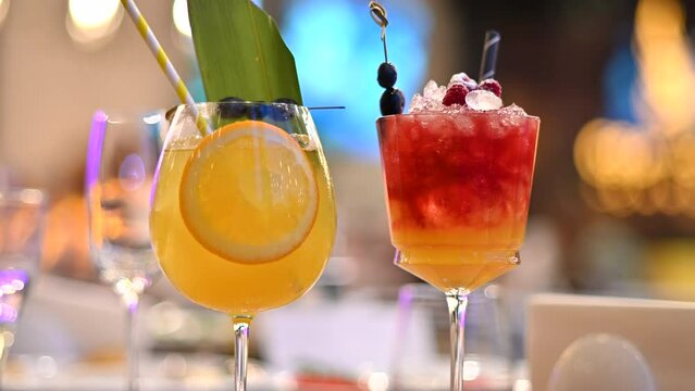 Orange and red cocktails, lemonade and vodca, mango juice, blueberries and ice
