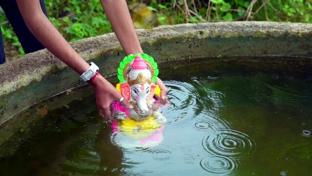 Lord Ganesh idol immersion in water during Indian festival Ganesha Chaturthi.
