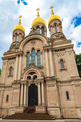 Obraz premium Nice close-up view of the west entrance of the famous Russian Orthodox Church of Saint Elizabeth, also called Greek Chapel, with its five gilded onion domes on the hill Neroberg in Wiesbaden, Germany.