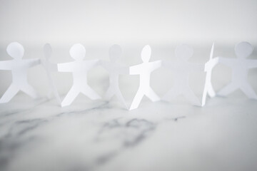manpower and teamwork, paper people chain with text on white marble background