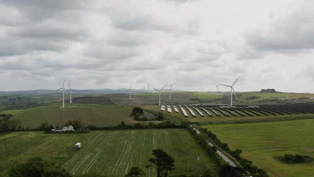 Dramatic View Of Wind Turbines And Solar Panels Near Saint Newlyn East Countryside In Cornwall, England, United Kingdom. Aerial Shot