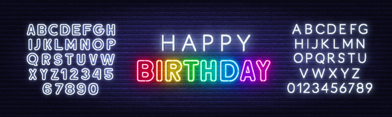 Obraz premium Happy birthday rainbow neon sign on a brick wall.