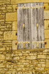 Fototapeta na wymiar Stone building with shutters window, France