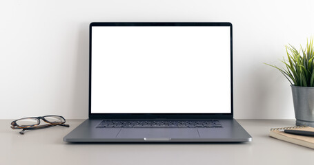 Modern laptop with blank white screen on minimalist desk. Mock up template