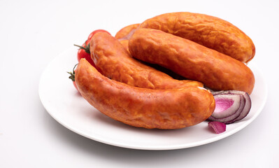 Smoked pork sausage on a white plate, isolated. Polish meat sausage, a packshot photo. 