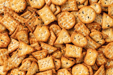 Saltine cracker background. Texture of salty crackers with black and white sesame seeds. Various...