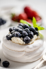 Delicious mini Pavlova meringue nest with blueberry and mint leaves