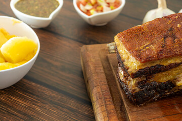 traditional brazilian barbecue beef rib, with bone and side dishes, close up