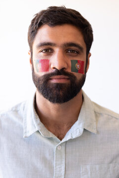 Vertical image of serious multiracial man with flags of portugal on face