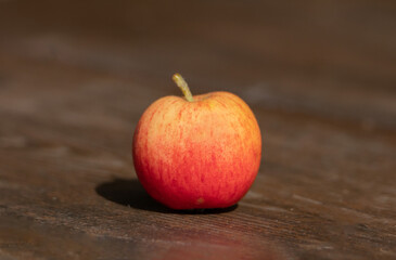 an isolated red apple on a plank in the foreground