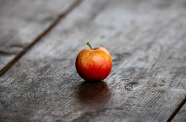 an isolated red apple on a plank in the foreground