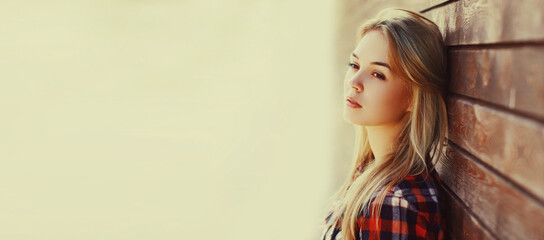 Close up portrait of beautiful young blonde woman looking away outdoors