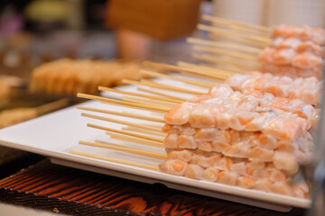 Grilled salmon belly Skewers on flat top grill at street market, Thailand street food