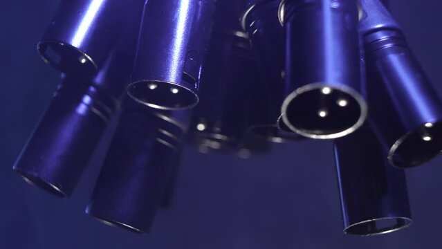 XLR cables hanging from a truss. With fog in the background and cold white lights