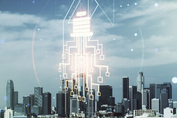 Double exposure of virtual creative light bulb hologram with chip on Los Angeles city skyscrapers...