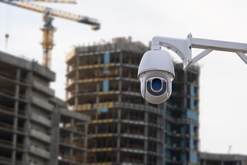 security CCTV camera or surveillance system with construction site on blurry background