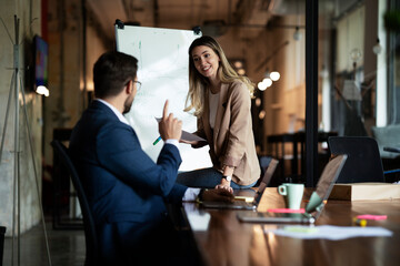 Businesswoman present her idea to working team. Young beautiful woman presenting businessplan..