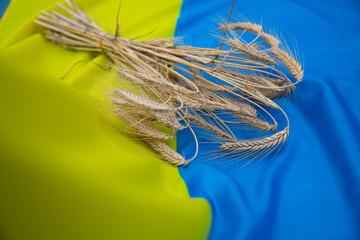 A bouquet of ripe golden spikelets of wheat on the background of the flag of Ukraine.