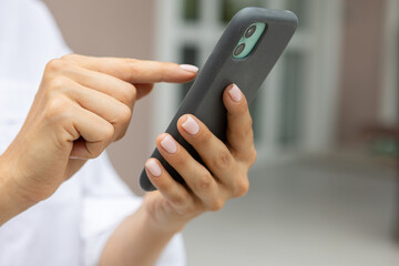 female hands hold a modern mobile phone on the street..education, modern app, shopping order, work online