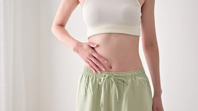 鏡でお腹をさする女性　顔無し