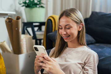 portrait of teenager girl using mobile phone in her room