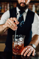 close up of barman stirring ice in glass