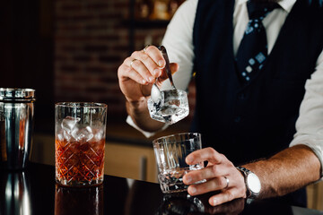 close up of barmen adding ice in glass