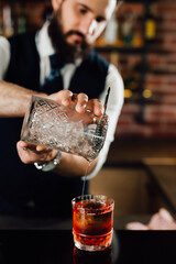 close up of barman pouring cocktail into glass