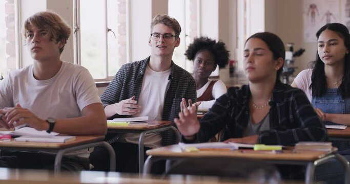 Education, learning and classroom with students giving an answer to a question while in school. Growth, development and studying with young people in high school class during a group study lesson