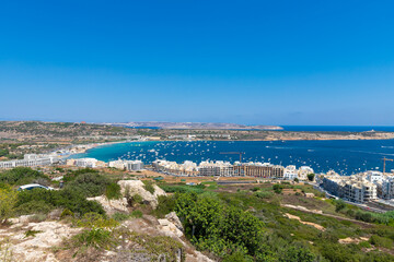 a view on the bay of Mellieha, Malta seen from a viewpoint. It gives a perfect view on the resorts, boats and the turquoise blue water