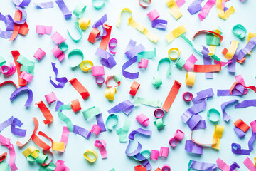 Colorful paper confetti on blue background.