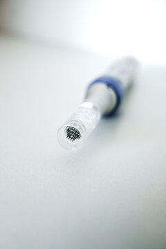 Microneedles for collagen induction therapy. Apparatus with needles close-up on grey background. Vertical photo
