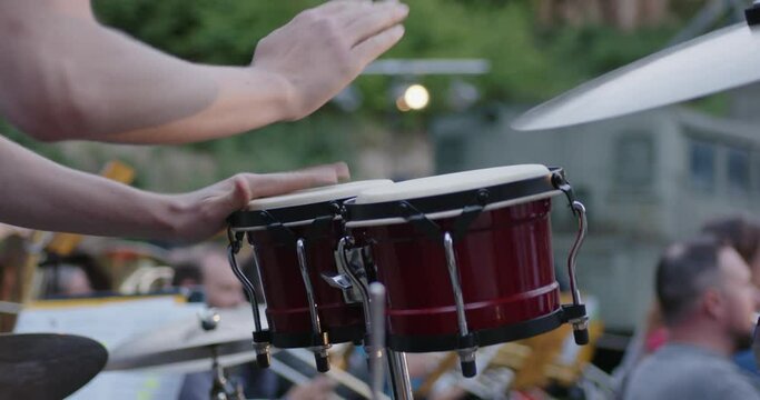 Drumer plays with hands on two Drums
