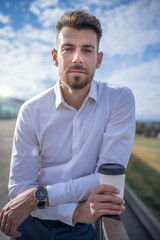 Male entrepreneur during coffee break on embankment