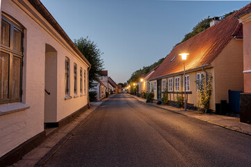 paved street with a timber framed house just after sunset in the idyllic town Mariager