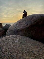 sunset on the rocky shore. stones lined with a slide in the setting sun