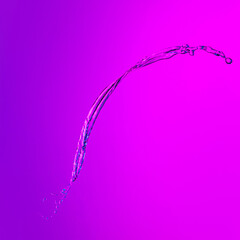 Flying splash transparent liquid or water on lilac color background in neon light. Minimalism, art, fashion