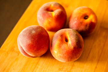Fototapeta na wymiar Ripe peaches on wooden board close up