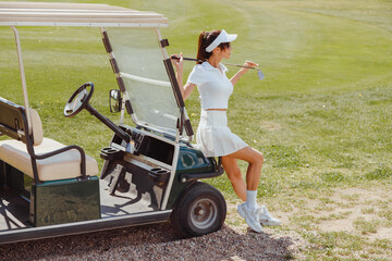 Beautiful woman in white outfit standing near golf cart. Rich lifestyle - Powered by Adobe