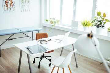 Interior of modern medical office. Doctor's workplace. Empty Doctors Office Viewed Through Open Door. Empty doctor's office with white furniture and walls.