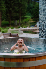 Happy little boy relaxing in outdoor hot tub. Summer holiday, vacation concept.