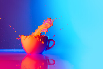 Huge milk splashes. Cup of coffee with milk standing on mirror surface over gradient blue white background in neon light. Concept of art, beauty, drinks