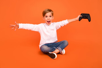 Full size photo of cool funky kid playing joy stick celebrate success victory isolated vivid color background