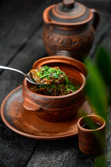 charkoe baked in a jug sprinkled with greens on the table with a spoon
