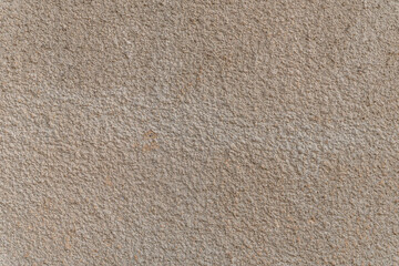 abstract background of an old embossed plastered wall painted beige close up